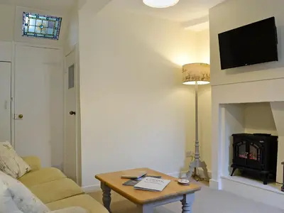 a living room with a couch and a table at Jasmine Cottage in Keswick