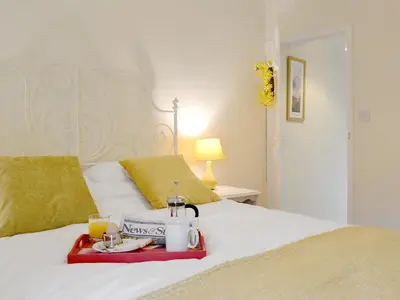 a bed with a tray of food and drinks on it at Jasmine Cottage in Keswick