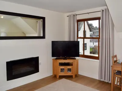 a living room with a flat screen tv next to a window at High Views in Keswick