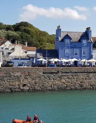 two people in a kayak in the water near a building at The Waterfront in Portpatrick