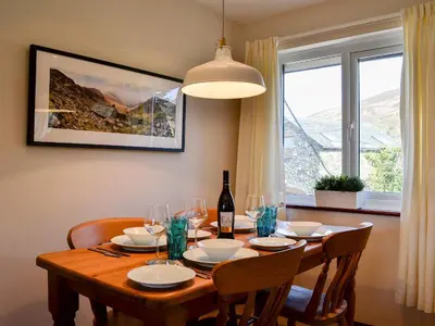 a dining room table with glasses and a bottle of wine at Melbreak in Lorton