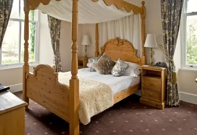 a bedroom with a canopy bed and two night stands at New Dungeon Ghyll Hotel in Great Langdale