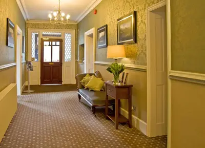 a hallway with a chair and a table and a door at New Dungeon Ghyll Hotel in Great Langdale
