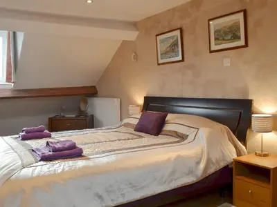 a bedroom with a large bed with purple towels on it at Bianca Rose in Keswick