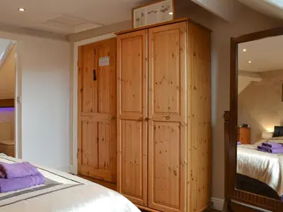 a bedroom with a large wooden cabinet next to a bed at Bianca Rose in Keswick