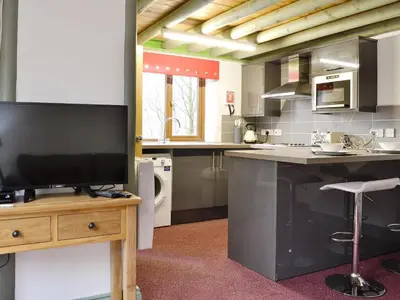 a kitchen with a flat screen tv on a wooden table at Harrison's Lodge - Uk1259 in Threlkeld