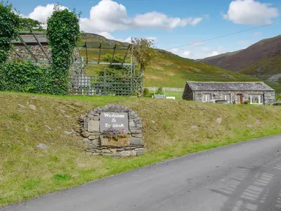 a sign sitting on the side of a road at Harrison's Lodge - Uk1259 in Threlkeld