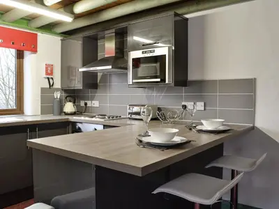a kitchen with a large island with two chairs at Harrison's Lodge - Uk1259 in Threlkeld