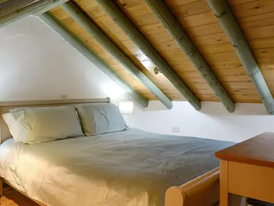 a bed in a room with wooden ceilings at Harrison's Lodge - Uk1259 in Threlkeld