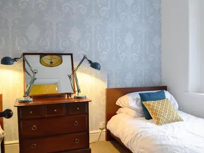 a bedroom with a bed and a dresser with a mirror at Gilbert's Warrant in Keswick