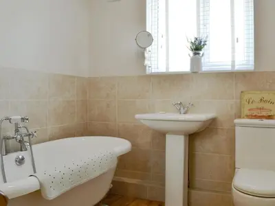 a bathroom with a bath tub and a sink at The Tottsie in Bassenthwaite