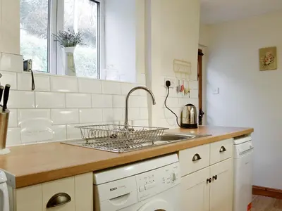 a white kitchen with a sink and a dishwasher at The Tottsie in Bassenthwaite