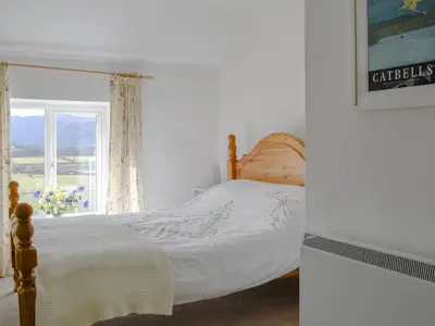 a bedroom with a bed and a window at The Tottsie in Bassenthwaite