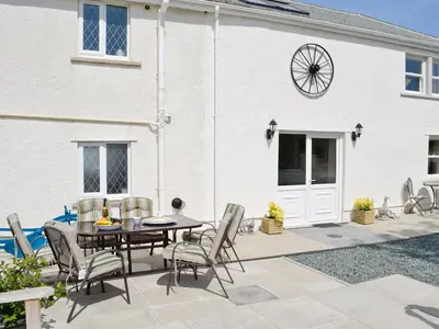 a patio with a table and chairs in front of a building at Greengill Farm Holiday Cottage - Ukc2768 in Gilcrux