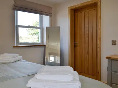 a room with two beds and a window and a window at Greengill Farm Holiday Cottage - Ukc2768 in Gilcrux