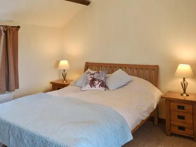 a bedroom with a bed with pillows and two lamps at Brodie Cottage in Aspatria