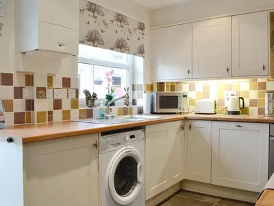 a kitchen with a washer and dryer on the counter at The Costins in Allonby