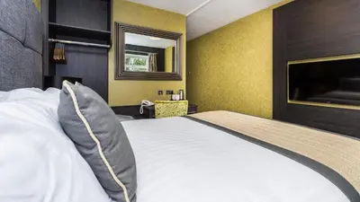 a bedroom with a bed with two pillows on it at The Melbreak Hotel in Great Clifton