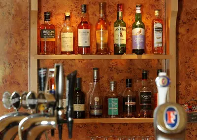 a shelf filled with lots of bottles of alcohol at Cressfield Country House Hotel in Ecclefechan
