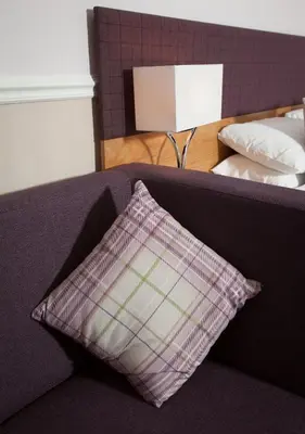 a pillow sitting on a couch next to a bed at Cressfield Country House Hotel in Ecclefechan