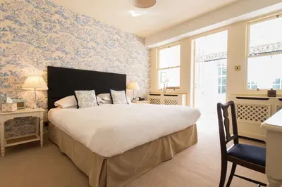a bedroom with a large bed with blue floral wallpaper at Cavens Country House, DINNER INCLUSIVE! in Kirkbean