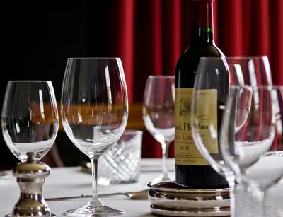 a bottle of wine sitting on a table with wine glasses at Cavens Country House, DINNER INCLUSIVE! in Kirkbean
