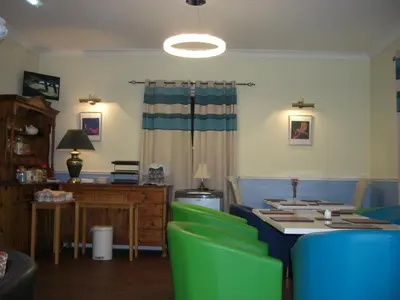 a living room with a table and green chairs at Lynebank House Hotel, Bed & Breakfast in Carlisle