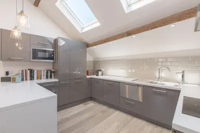 a kitchen with gray cabinets and a skylight at Sail Lofts in Douglas