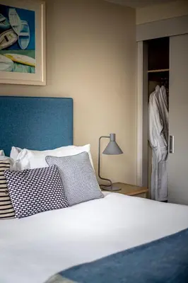 a bedroom with a bed with a blue headboard and a lamp at Sail Lofts in Douglas