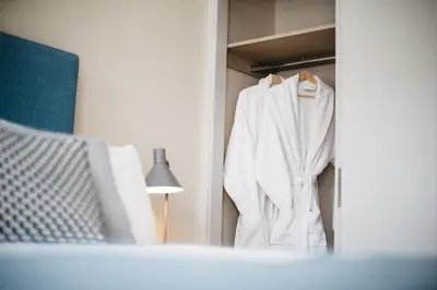 a white robe is hanging on a closet at Sail Lofts in Douglas