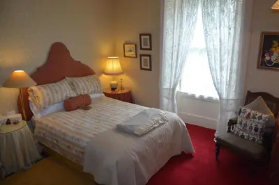 a bedroom with a bed and a window and a chair at Scaurbridge House in Thornhill