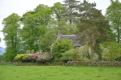 a house in a yard with flowers and trees at Scaurbridge House in Thornhill