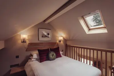 a attic bedroom with a bed and a window at Tweedies Bar and Lodge in Grasmere