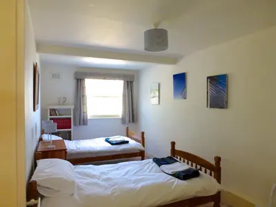 a bedroom with two beds and a window at Shore Cottage in Dumfries