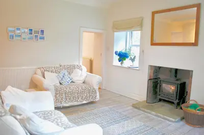 a living room with a couch and a fireplace at Little Dunbar Cottage in Kirkbean