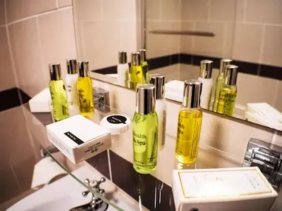 a bathroom with yellow bottles on a counter in front of a mirror at Glen Mona in Douglas