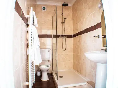 a bathroom with a shower and a toilet and a sink at Glen Mona in Douglas