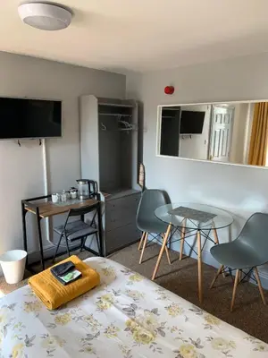 a room with a bed and a table and chairs at Hall Park Hotel self check in in Workington
