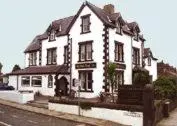 a large white building on the side of a street at Hall Park Hotel self check in in Workington