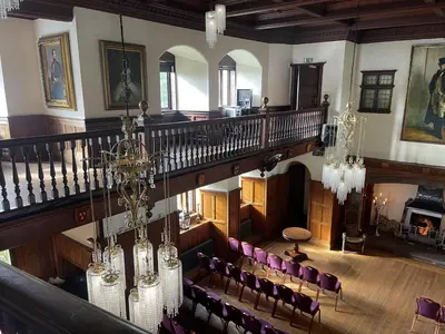 an overhead view of a room with a staircase and chairs at Dalston Hall in Carlisle