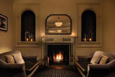 a living room with two couches and a fireplace at Hetland Hall Hotel in Dumfries