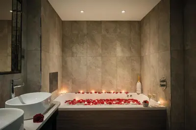 a bathroom with a bath tub with candles in it at Hetland Hall Hotel in Dumfries