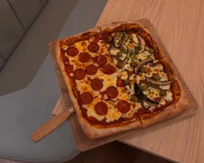 a large pizza sitting on top of a wooden table at Lyzzick in Keswick
