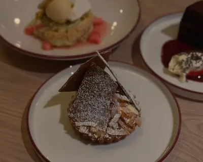 a piece of cake on a plate on a table at Lyzzick in Keswick