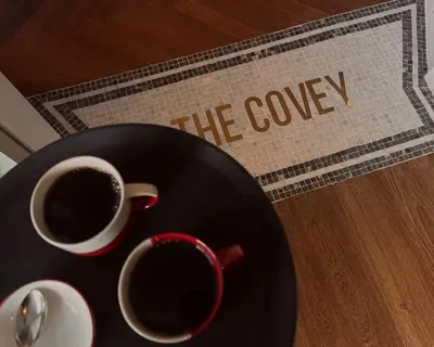 two cups of coffee on a table with the curry sign at Lyzzick in Keswick