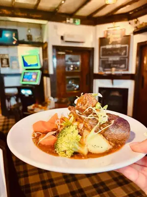 a person holding a plate of food on a table at The Ayrshire and Galloway in Ayr
