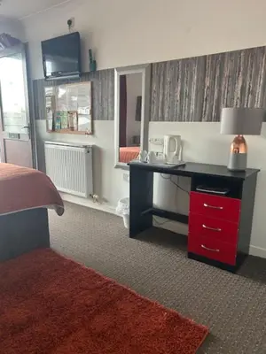 a bedroom with a desk with a bed and a mirror at The Thistle in Stranraer