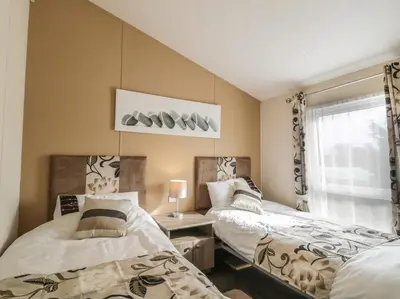 a bedroom with two beds and a window at Cheri in Mainsriddle