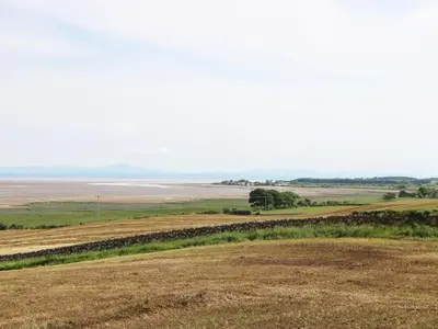 a view of a field with the ocean in the background at Cheri in Mainsriddle