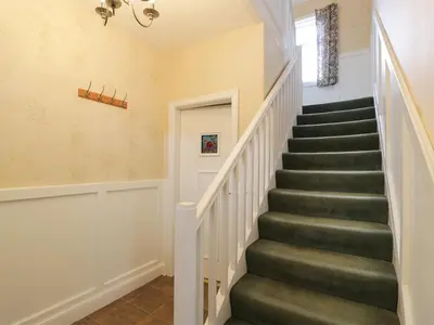 a staircase in a home with green carpeting and a window at 27-29 St Marys Place in Kirkcudbright